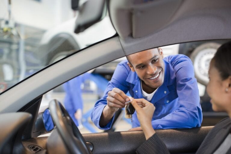 Hyundai technician giving keys to woman in car